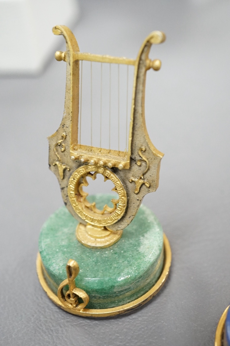 A set of four mid 20th century Italian 800 standard gilt white metal miniature model string instruments, including a lyre and lute, each mounted on a circular hardstone base, including jasper and adventurine quartz, 65mm